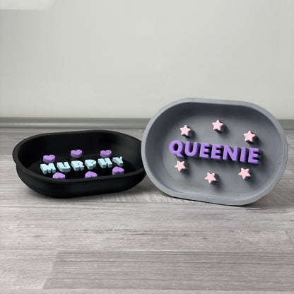 Two multicolour slow feeders with pet names: MURPHY with hearts and QUEENIE with stars