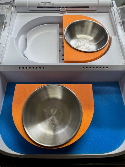Orange split twin bowl adaptor for SureFeed Connect: two separate halves, one fitted in the feeder and one removed