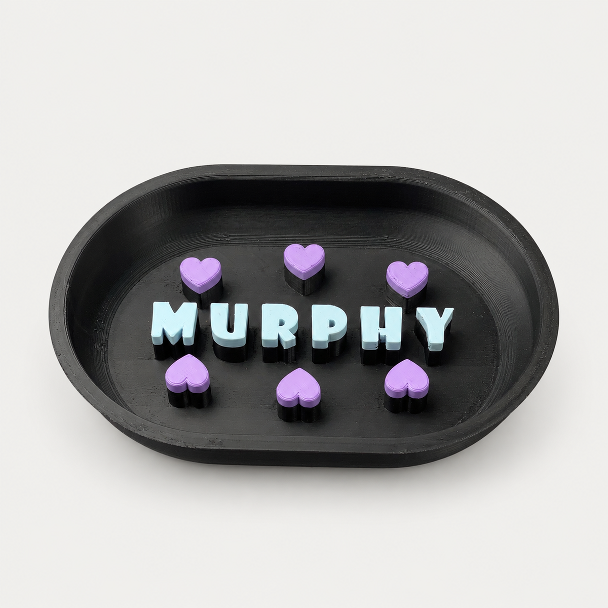 Schwarzer personalisierter Slowfeeder MURPHY mit hellblauen Buchstaben und violetten Herzen